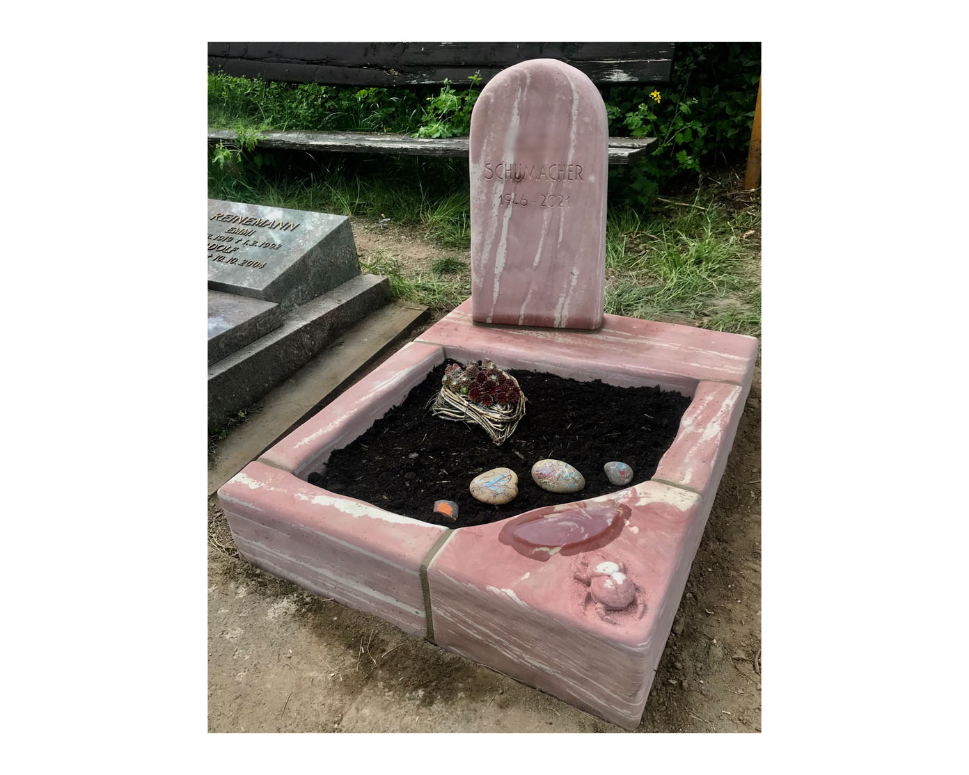 Grabmal aus rosafarbenem Marmor mit Grabeinfassung und Grabschmuck